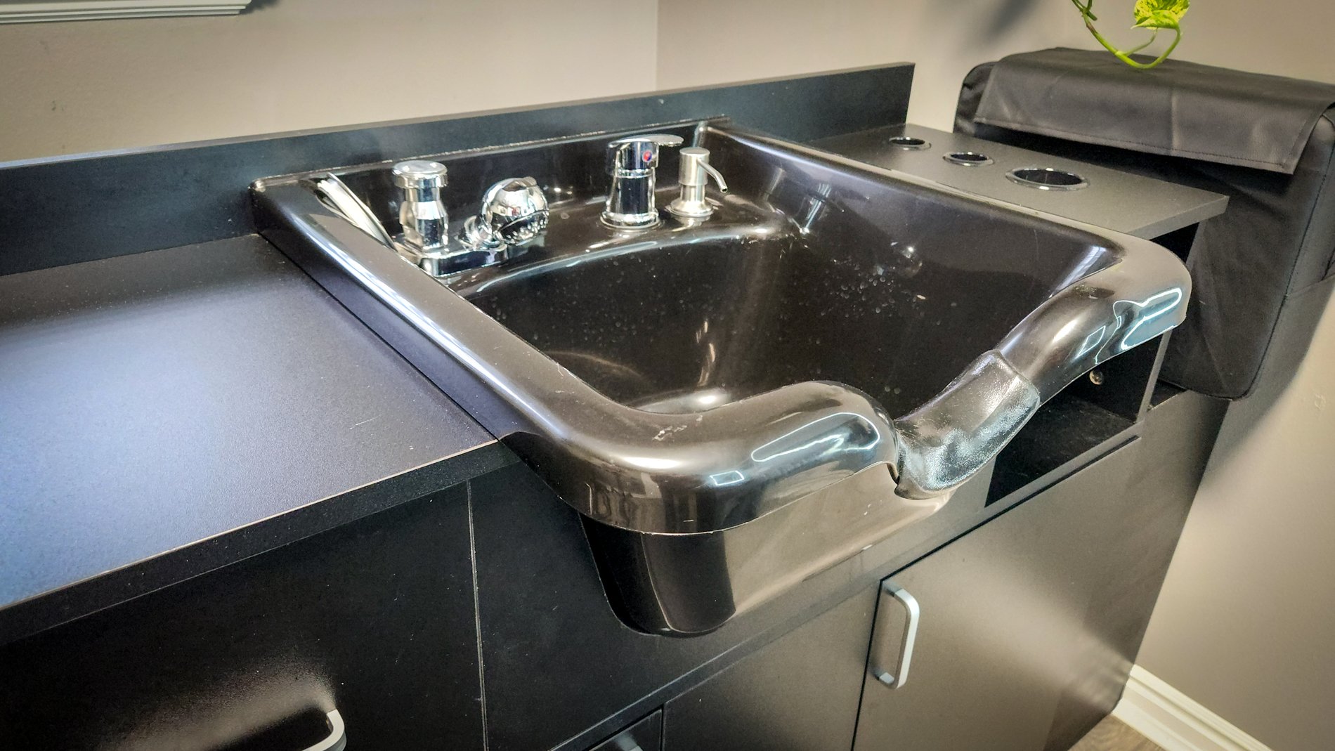 The salon studio at CGW Studios with a wash station, stylist chair, and dryers.