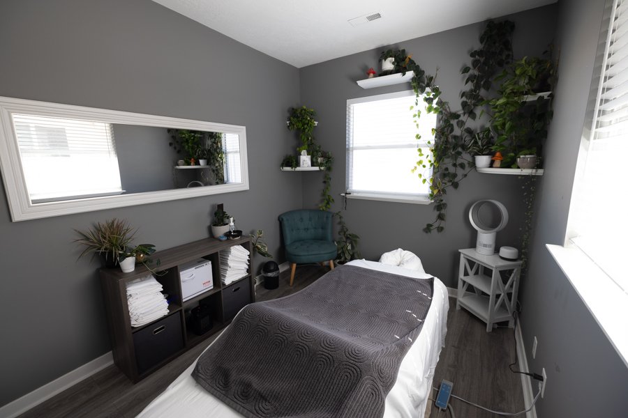 Inside Massage Studio 1 at CGW Studios: a calm, plant-filled treatment studio with natural light, a draped massage table, and curated details.