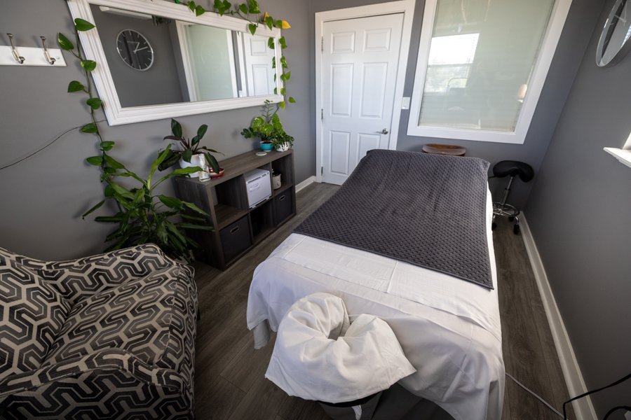 Wide view of Studio 2 at CGW Studios showing the full room, Ashiatsu ceiling bars, and massage table.